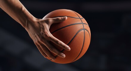Basketball being palmed low with one hand as if mid-dribble, fingertips pressing into the texture of the ball, captured with tension and control.