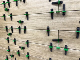Close up view of ceramic tile installation using plastic leveling spacers and clips for precise....