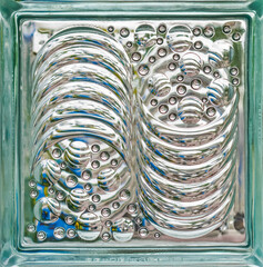 Textured Glass Block with Circular and Wavy Patterns. Close-up of decorative glass block featuring...