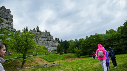 children, teenagers walk along the path, with backpacks, in  mountains to  ruins of the fortress,...
