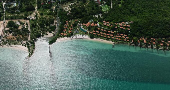 Coastline beach resort area with green surroundings, clear blue water, and palm trees. Ko Samui, Thailand.