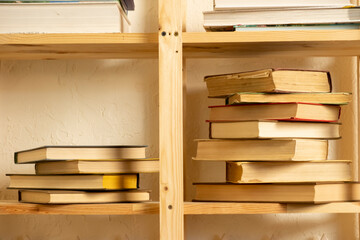 Stacked books on a wooden shelf in a cozy reading nook filled with literature