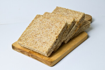 Close up view of whole wheat sliced bread on wooden cutting board with abstract product background. Isolated on white. Clipping path.