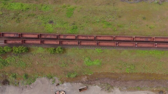 Aerial drone view top down of industrial train carts mining railway mineral ore transport in Scunthorpe England UK.