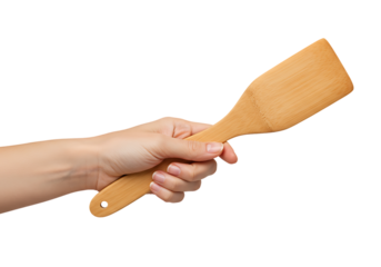 Human hand holding bamboo spatula isolated on black background for culinary projects