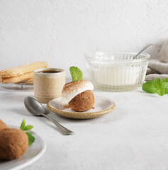 Cake Tiramisu balls with cream mousse and coffee on the kitchen table, copy space
