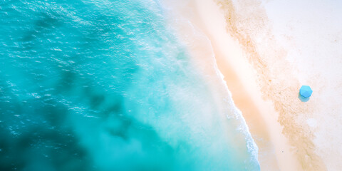 Aerial view of blue sea and white sandy beach.