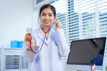 A compassionate Asian female veterinarian in a white lab coat, holding a stethoscope and ready to...