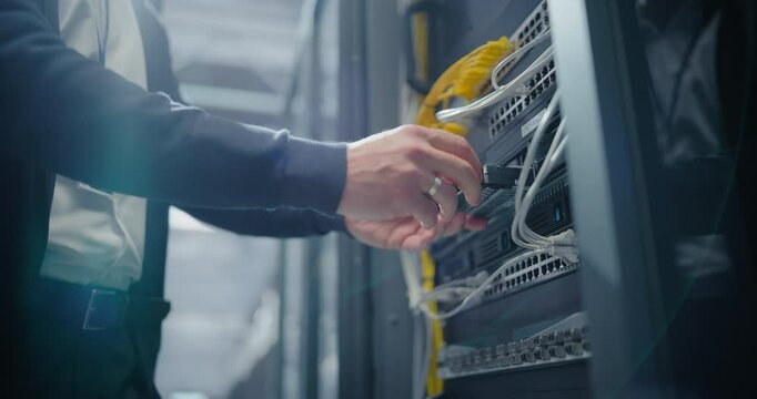 Anonymous IT Engineer Installing New Hard Drives and Other Hardware into a Server Rack System in a Data Center. IT Specialist Doing Maintenance, Running Diagnostics and Updating Equipment. Low Angle