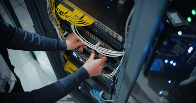 Anonymous IT Engineer Installing New Hard Drives and Other Hardware into a Server Rack System in a Data Center. IT Specialist Doing Maintenance, Running Diagnostics and Updating Equipment. High Angle