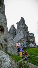 children, adults, teenagers walking along the path, in raincoats, majestic ruins, mountains, ruins...