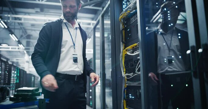Male IT Technician Working with Server Racks in a Modern Data Center. Providing Maintenance Work and Installing New Hardware for Database and Storage Hard Drives for AI Model Training and Compute