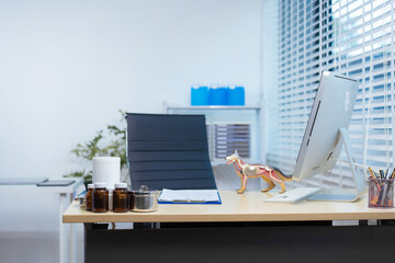 A well-organized veterinarian's office features a desk with a computer, medical supplies, and an...