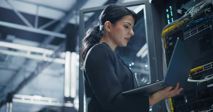 Portrait of an IT System Administrator Using Laptop Computer. Multiethnic Female Working on Cyber Security and Network Protection, Servicing Server Clusters and Providing Technical Diagnostics - Powered by Adobe