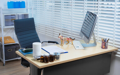 A well-organized veterinarian's office features a desk with a computer, medical supplies, and an...