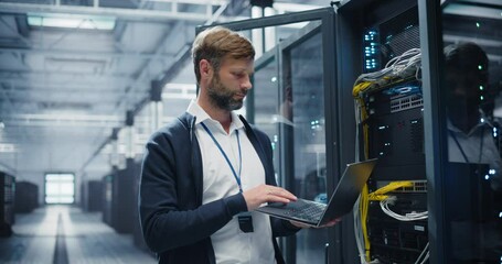 Portrait of a Data Center Engineer Using a Laptop Computer. Handsome Man Looking at Camera and Smiling. Information Technology Specialist Standing in a Facility with Operational Server Racks - Powered by Adobe