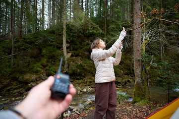 Man holding radio station giving to her girlfriend. Walkie talkie in the mountains. Concept of wireless communications. Off grid communication methods.