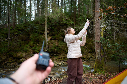 Man holding radio station giving to her girlfriend. Walkie talkie in the mountains. Concept of wireless communications. Off grid communication methods.