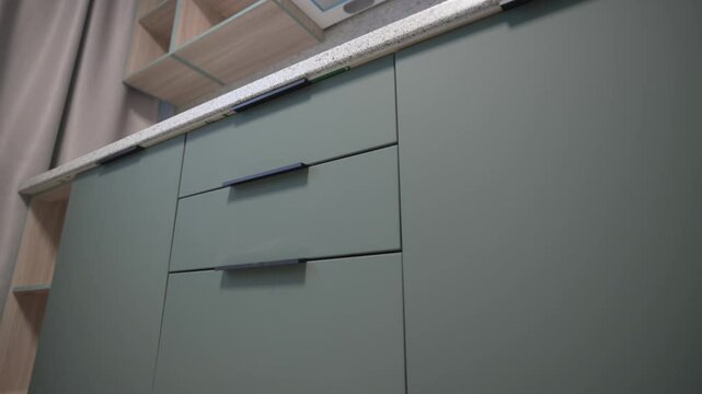 Soft-toned kitchen cabinets maximize space in compact area. Calm colors enhance light atmosphere. Balance of comfort and usability