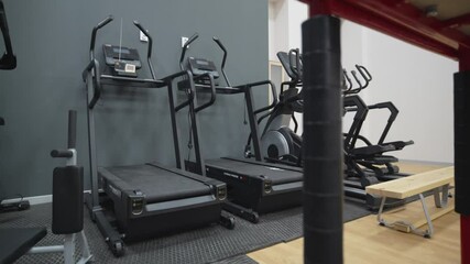 Long row of treadmills ready for dynamic energetic heart-pumping cardio sessions. Indoor space optimized for endurance and consistency