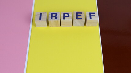 Form filling tax in Italy and with writing on wooden cube and yellow colored background.