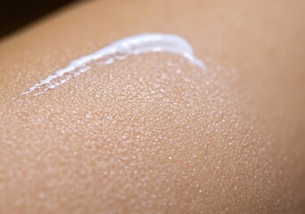 Fototapeta premium White moisturizer cream texture on skin with water droplets. Close-up skincare product application, hydrating treatment. Beauty cosmetic concept