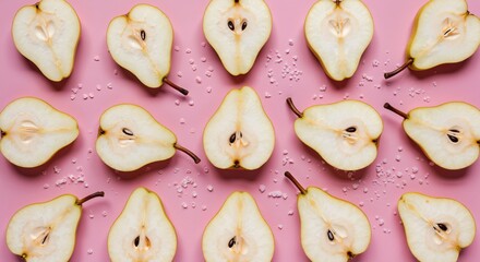 Sliced pears with seeds on pink background, water droplets scattered. Fresh organic fruit halves display, natural produce. Healthy nutrition concept