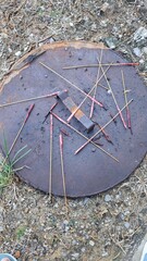 used firecrackers thrown on an old rusty manhole cover