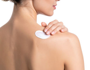 A woman applies white cream to her shoulder, highlighting skincare and self-care routines.