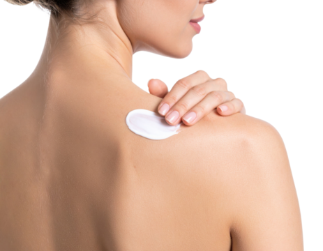 A woman applies white cream to her shoulder, highlighting skincare and self-care routines.