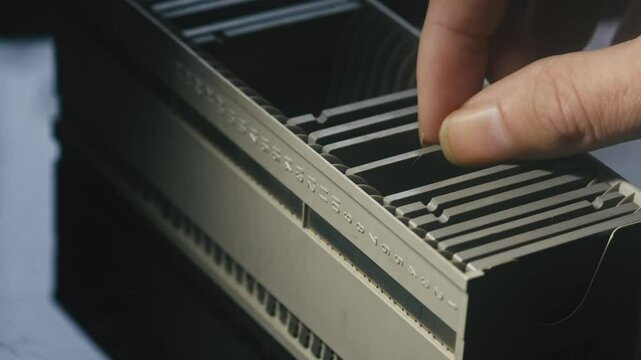 Fingers searching in box of diapositive photo film presentation slides CLOSE-UP