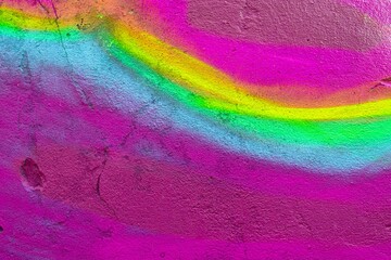 Vibrant graffiti texture featuring neon pink, green, yellow swirls on rough wall. 80s, 90s style,...