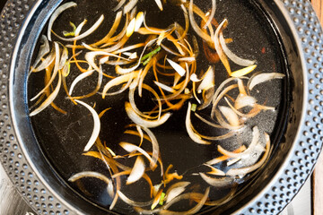 Closeup sukiyaki or hot pot to boiling water, steam or suki soup bubbles, heat vegetables for a healthy dinner or lunch at Japanese food restaurant in Thailand