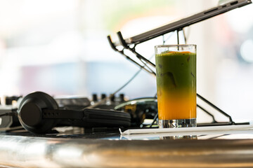 A glass of iced matcha latte with orange juice