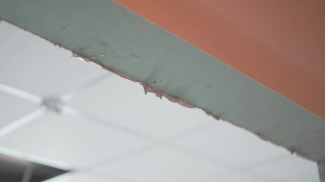 Smooth metal spatula spreads soft filler evenly across doorframe edge. Careful motion ensures clean precise finish on rough opening