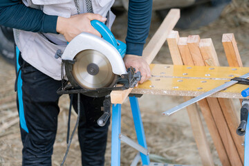 Skilled Worker Cutting Wood with Circular Saw in Outdoor Workshop