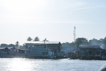 Southeast asian fishing village waterfront scene with boats and houses