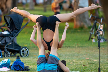 outdoor yoga, partner acrobatics, acro balance, fitness routine, strength flexibility, natural setting, body control, healthy lifestyle, sunrise session, morning workout, green wellness, tranquil