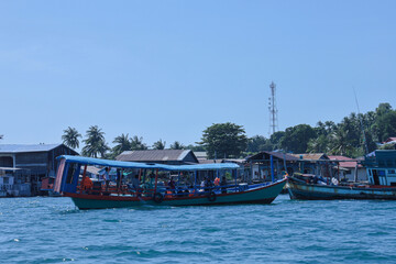 Passenger boat on tropical waters near a village