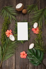 Elegant wedding and birthday card invitation design on wooden table with tropical greenery and flowers