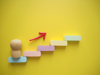ステップを上がるイメージ　人形と矢印