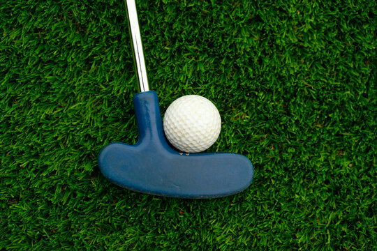 Blue Golf Putter and White Ball Positioned on Lush Green Turf as Concept of Fitting Objects