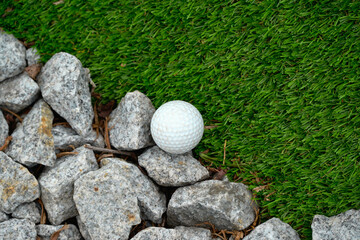 Golf Ball Beside Rocks and Grass on a Golf Course as a Symbol of Connection Between Two Concepts