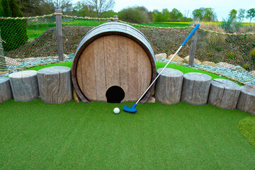 Miniature Golf Scene Featuring Barrel Obstacle on Green Course