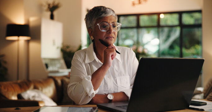 Mature woman, laptop and remote work from home with decision, review or notes for project management. Person, virtual assistant and computer with insight, feedback and freelance career at apartment