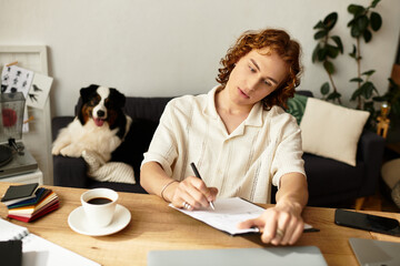 Young man enjoys a cozy afternoon at home while journaling and sipping coffee