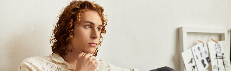 Contemplative young man enjoys a cozy moment at home while lost in thought