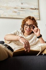 Obraz premium Young man enjoys cozy reading time at home while relaxing on a comfortable sofa