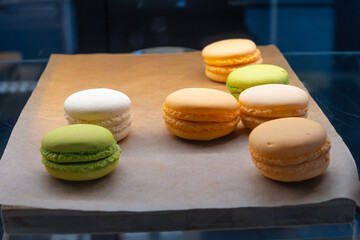 Vibrant Assortment Of French Macarons On Rustic Paper. Colorful French Macarons Displayed On Rustic Paper With A Variety Of Flavors.