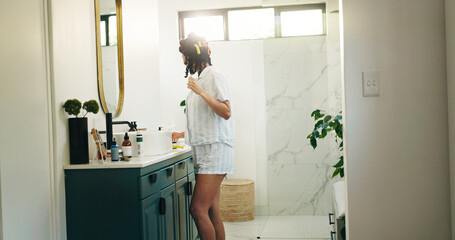 Hairstyle, curls and mirror with woman in bathroom for self care, grooming and treatment. Beauty, hair tools and diy routine with person and curling rods in home for cosmetics, volume and growth